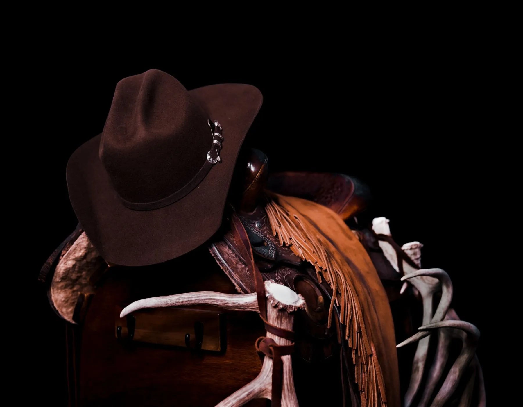 brown felt cattleman cowboy hat on a saddle 
