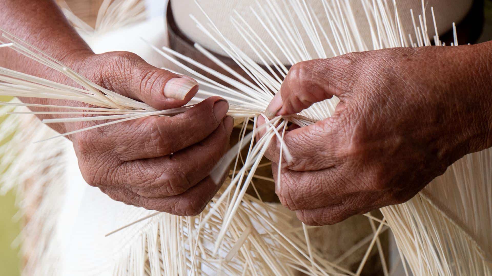 person weaving white straw