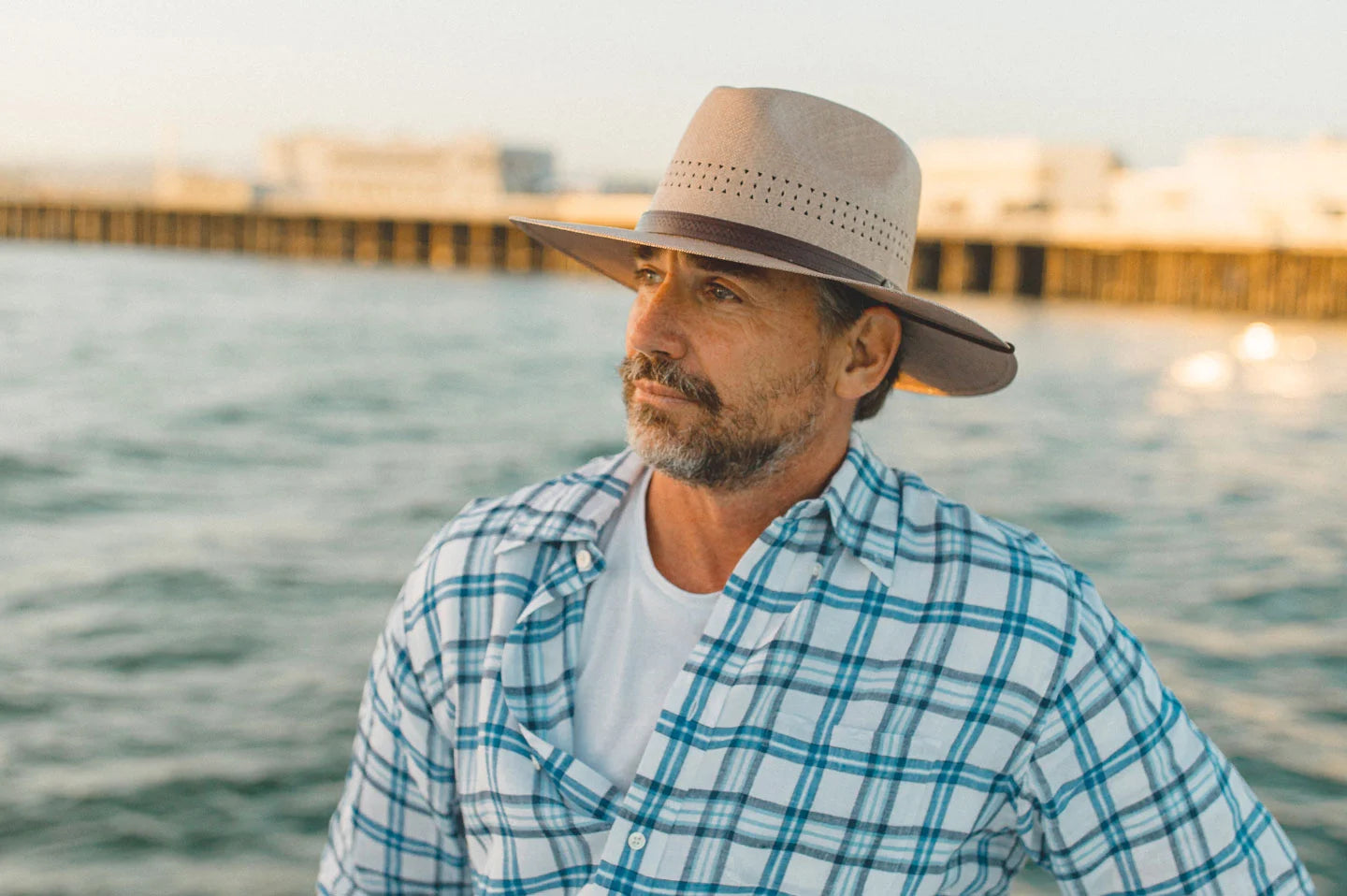 Man next to pier wearing the Barcelona mens straw hat by American Hat Makers