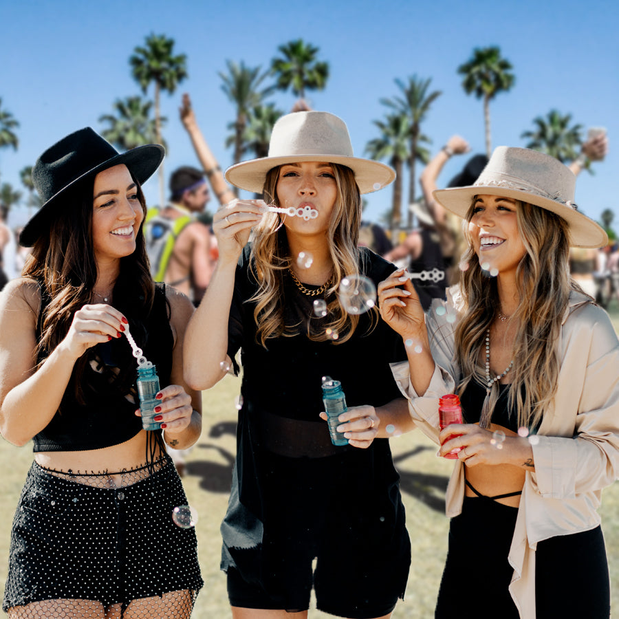 Three women wearing different styles of hats on a festival season