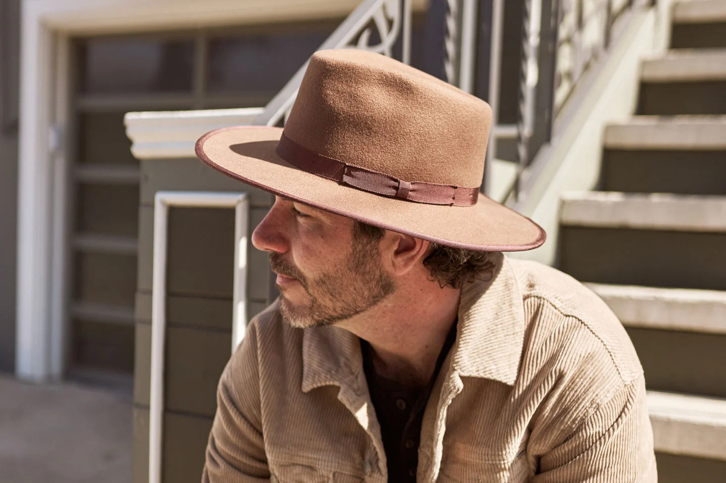 Man sitting on steps wearing the Bondi mens felt hat by American Hat Makers