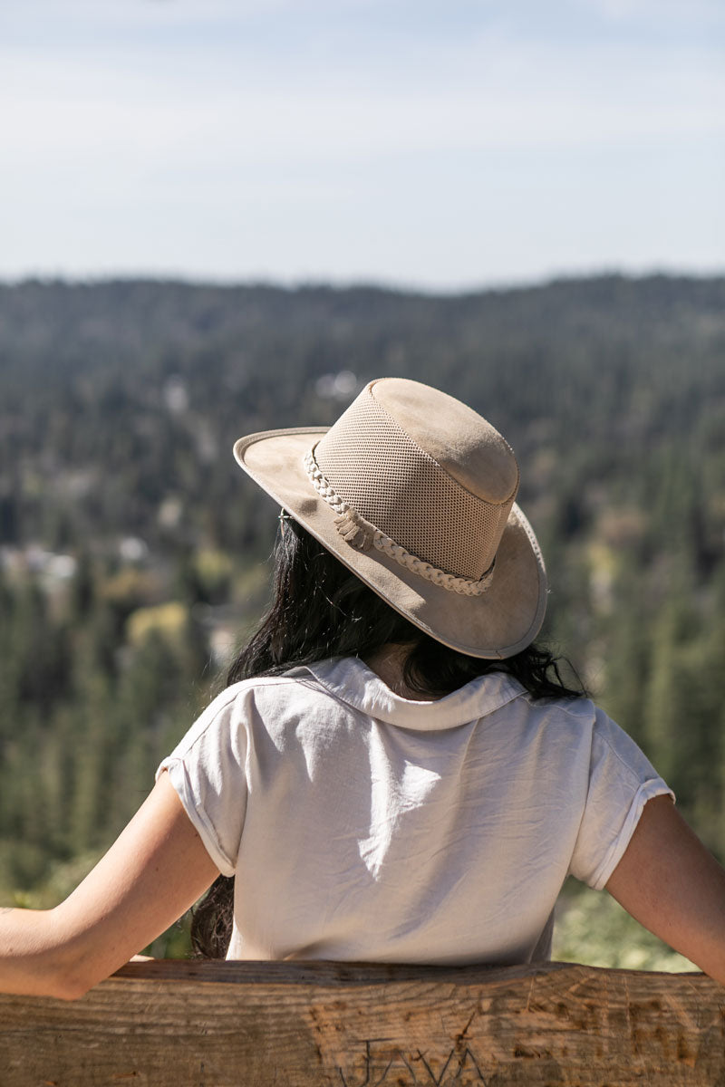 A man sitting down wearing a latte sun hat