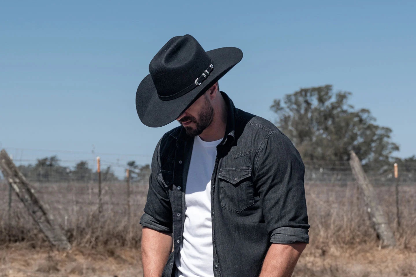 Cowboy standing in field while wearing the Cattleman mens cowboy hat by American Hat Makers