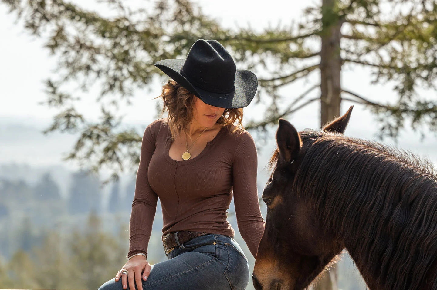 Woman petting horse while wearing the Cattleman felt cowboy hat by American Hat Makers