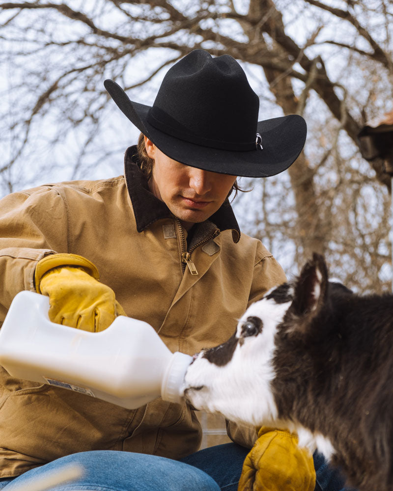 A man on the ranch wearing a black felt cowboy hat