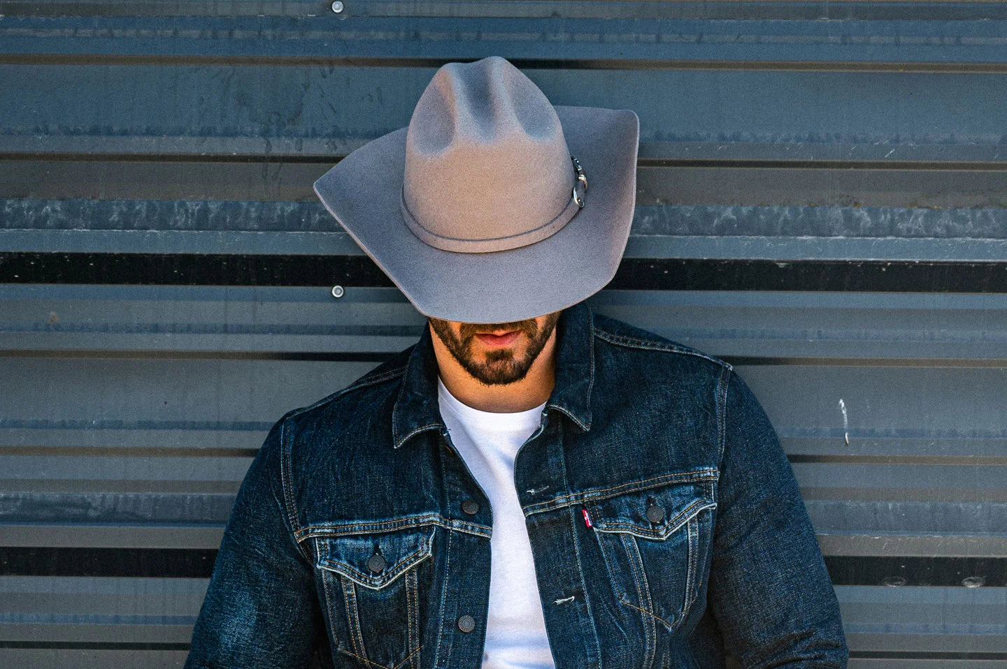 Cowboy against wall with the Cattleman felt cowboy hat by American Hat Makers