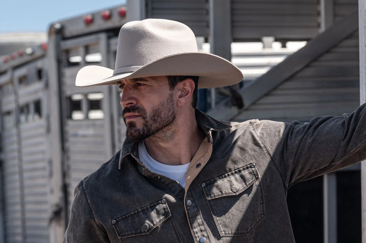 Man standing next to trailer while wearing the cattleman sand felt cowboy hat by American Hat Makers