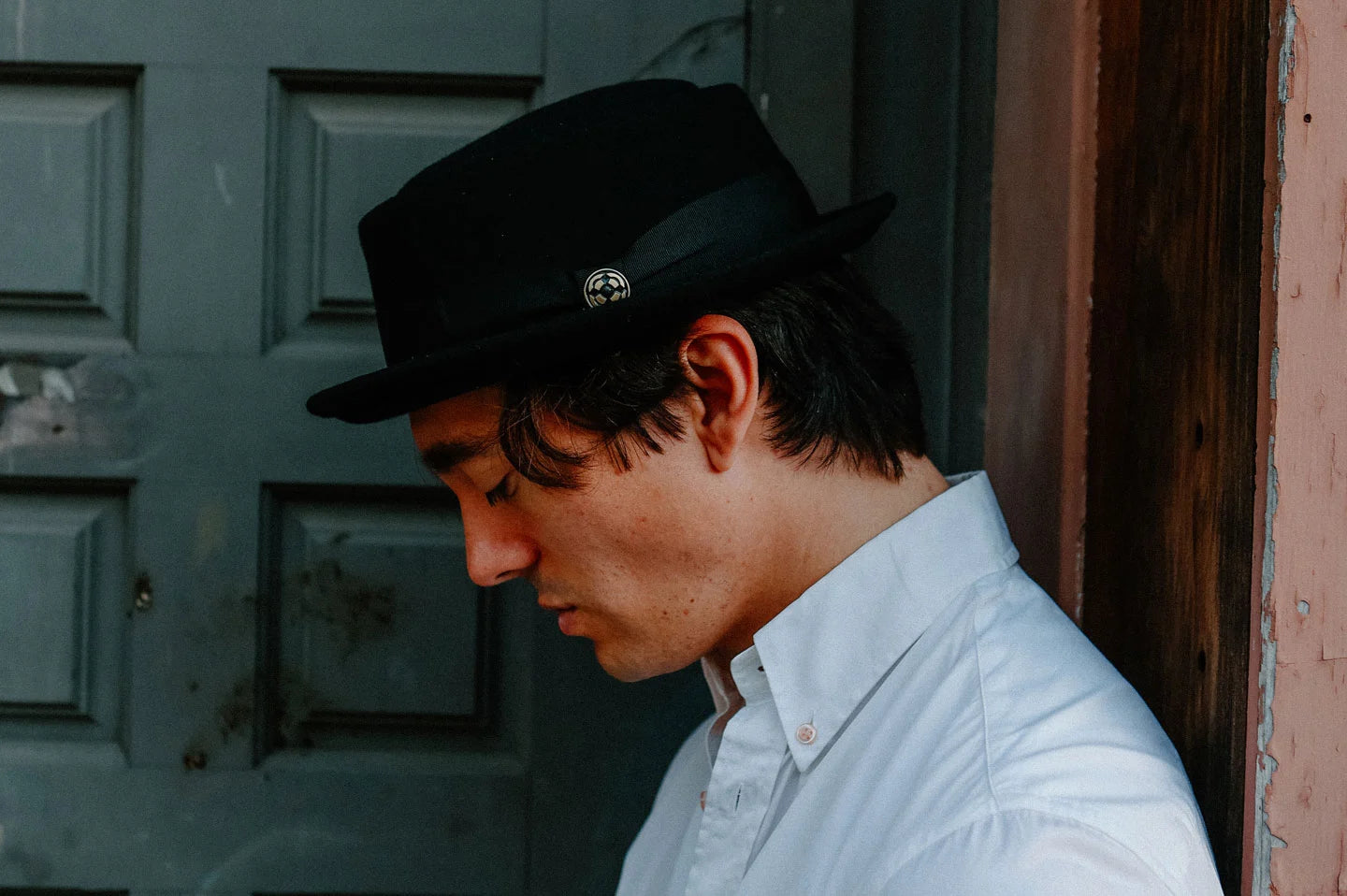 Man in doorway wearing the Chi Town mens pork pie hat by American Hat Makers