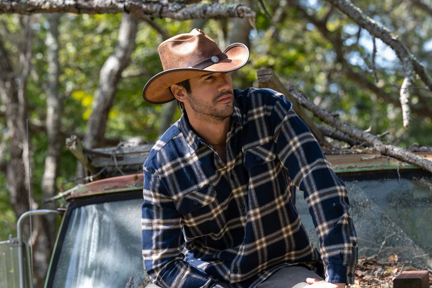 Man sitting on car wearing the cyclone mens leather hat by American Hat Makers