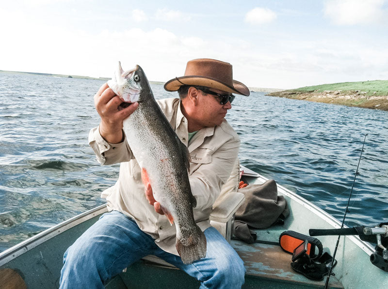 A man who goes fishing wearing a brown leather hat