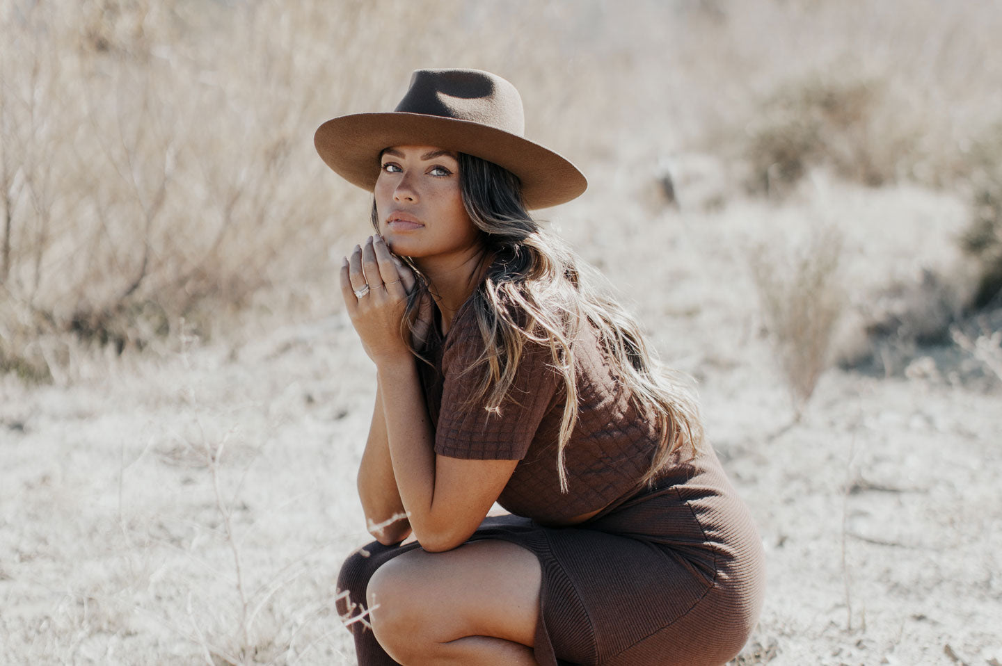 Woman sitting desert wearing the Jawa womens fedora hat by American Hat Makers