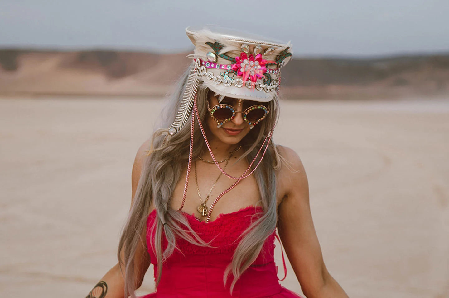 woman in red outside the desert wearing a couture hat by american hat makers