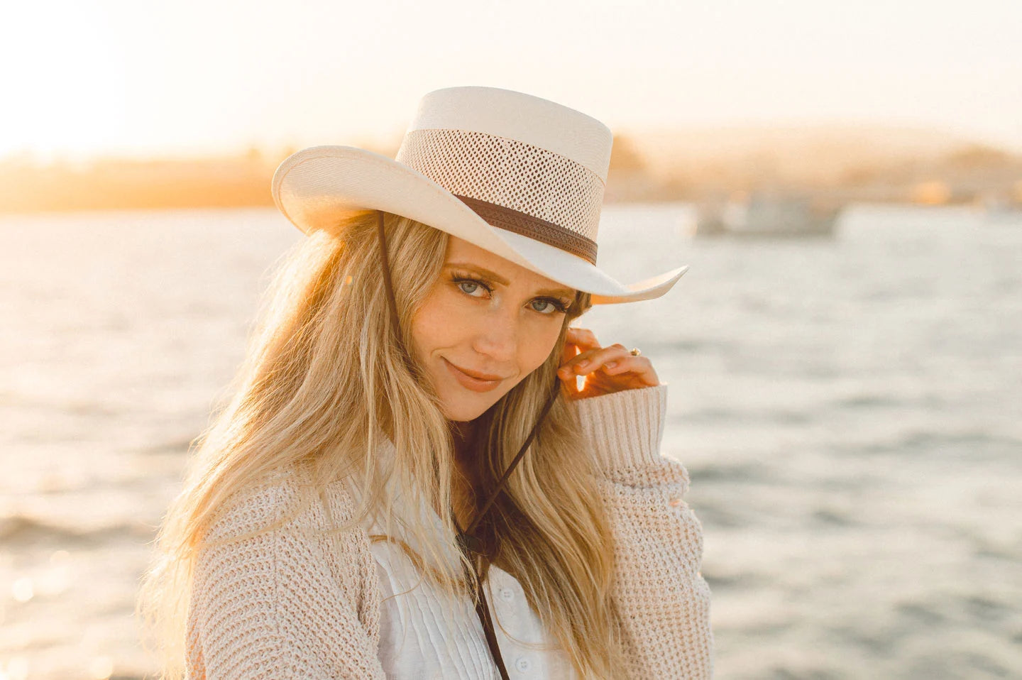 Woman next to ocean wearing the Madrid womens pork pie hat by American Hat Makers