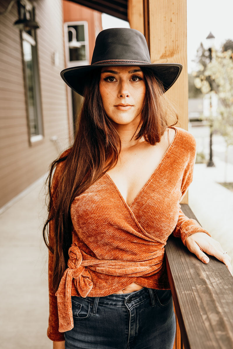 A woman outside a building wearing a midnight rider black leader hat