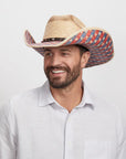 A smiling man wearing a Patriot sombrero with a patterned brim.