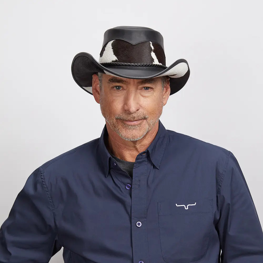 Middle-aged man smiling at the camera, wearing a black Pinto leather hat and a dark blue button-up.