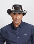 Middle-aged man smiling at the camera, wearing a black Pinto leather hat and a dark blue button-up.