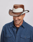 Middle-aged man smiling, wearing a brown Pinto leather hat and a dark blue button-up.