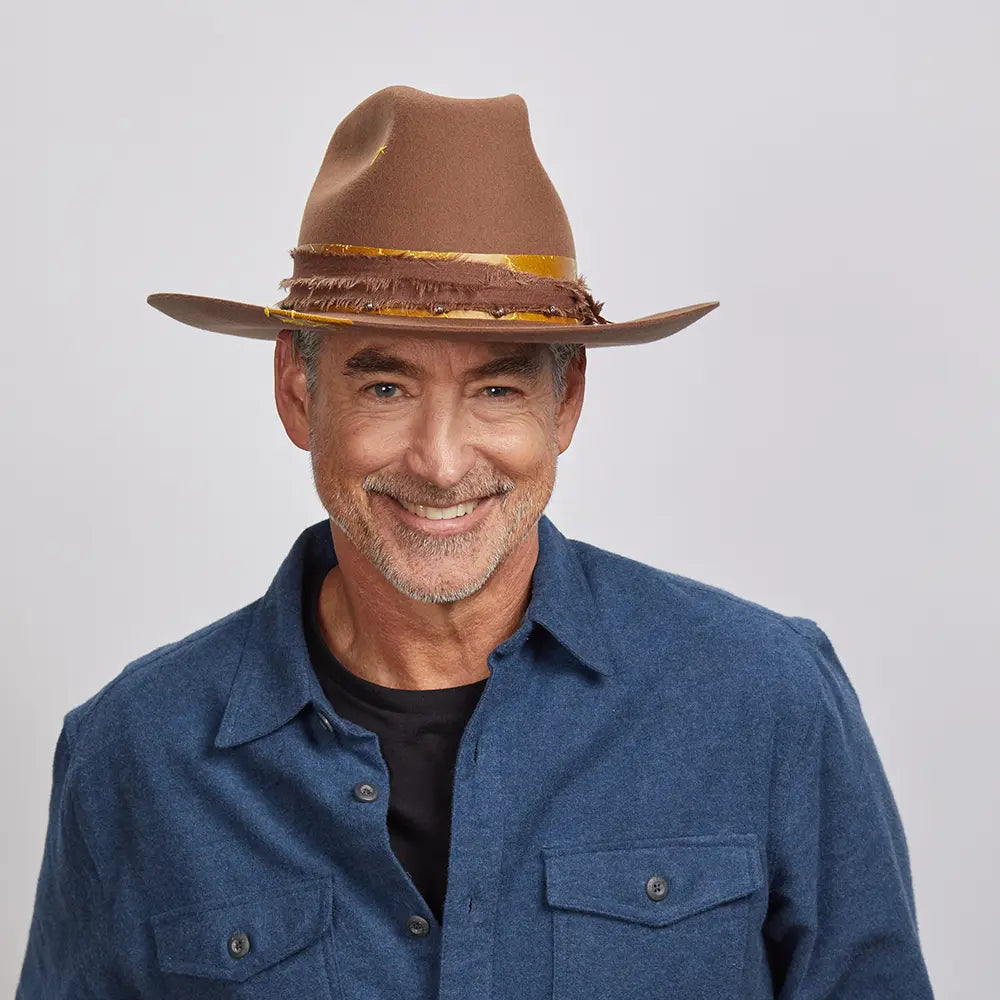 Man in a blue shirt wearing a brown Ralston hat