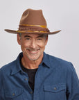 Man in a blue shirt wearing a brown Ralston hat