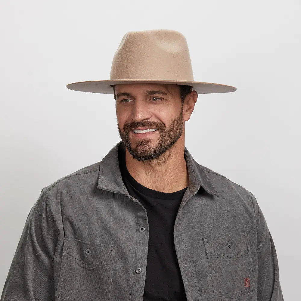 Man with a beard smiling, wearing a tan Rancher hat and a dark gray shirt.