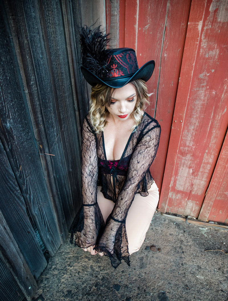 A woman on a see through dress wearing a reversible red and silver top hat