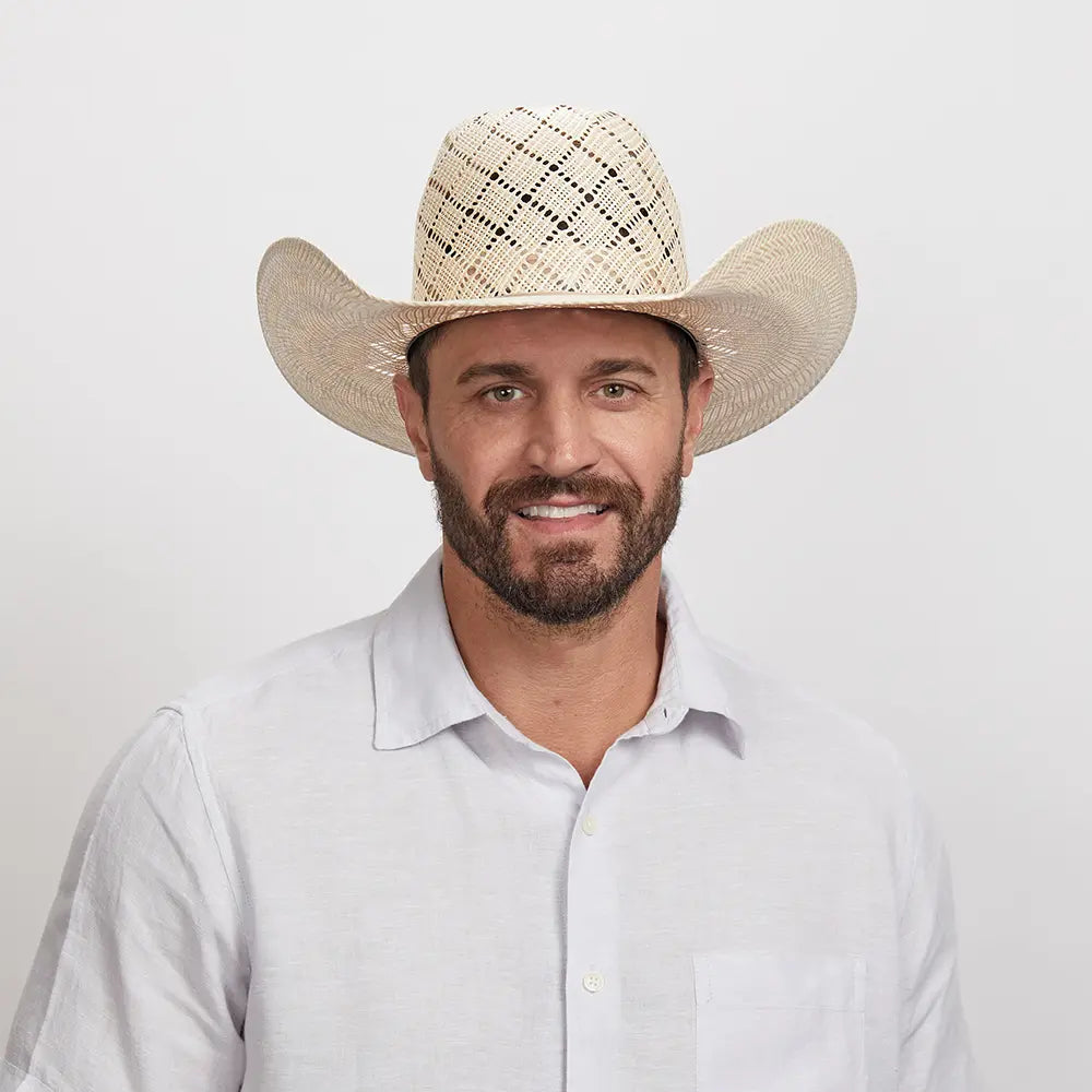 Man with a beard smiling at the camera, wearing a Revolver Cowboy Hat and a white button-down shirt.
