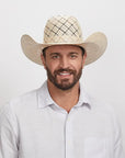 Man with a beard smiling at the camera, wearing a Revolver Cowboy Hat and a white button-down shirt.