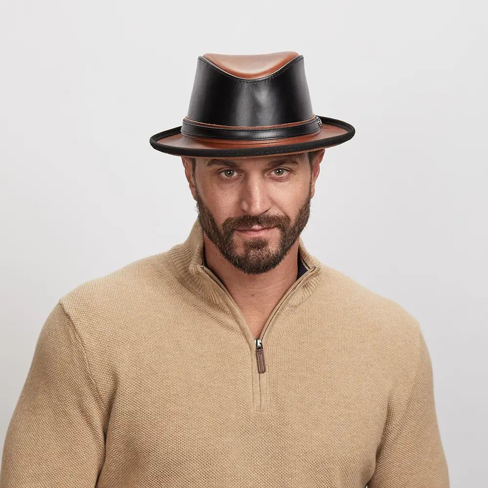 A young man wearing a brown long sleeves and a black leather fedora