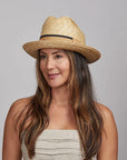 Woman with dark hair wearing a Sawyer Straw Hat and a beige top.