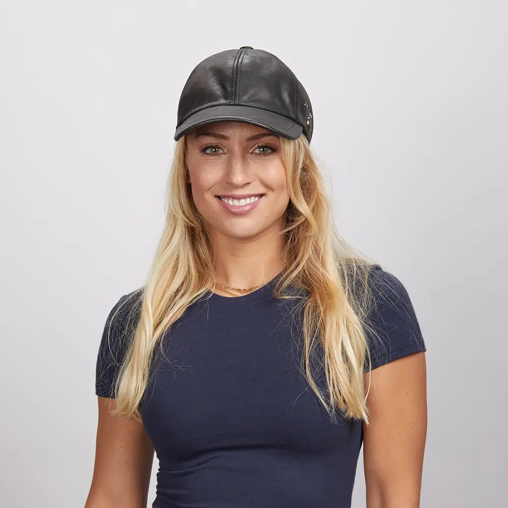 A young woman wearing a black leather cap and a blue shirt
