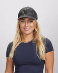 A young woman wearing a black leather cap and a blue shirt