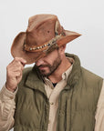Man tipping a Sidewinder Leather Cowboy Hat, wearing a green button-up jacket over a black shirt