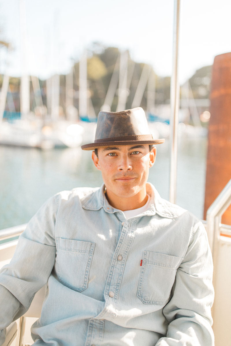 A man on a boat wearing a chocolate leather hat