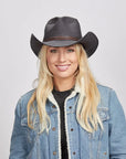 A blonde woman in denim jacket wearing the Black Stockade Vegan Cowboy Hat