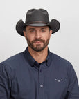 A man in navy shirt wearing the Stockade Black Vegan Cowboy Hat