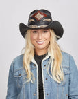 A blonde woman wearing a Black Storm Cowboy Hat and a blue denim jacket with white fleece collar.