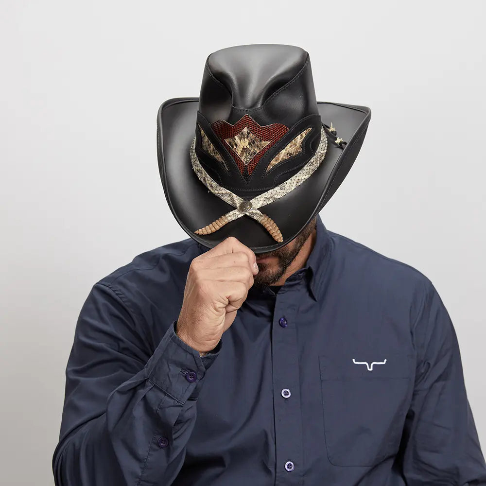 A man in a navy shirt tipping his Black Storm Cowboy Hat.
