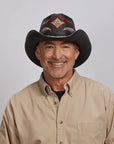 An older man wearing a Black Storm Cowboy Hat, posing in a light khaki shirt.