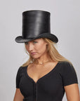 Woman wearing a black leather top hat with a confident expression