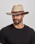 A man wearing the Summit Oatmeal Felt Leather Fedora Hat, looking slightly to the side.