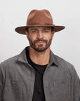 A man wearing the Summit Saddle Felt Leather Fedora Hat
