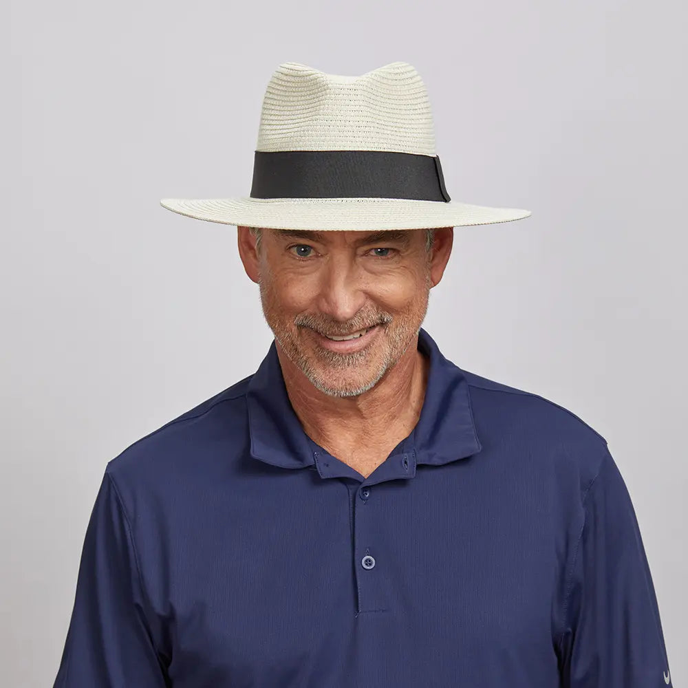 Middle-aged man smiling and looking straight, wearing a Cream Afternoon Fedora Hat and a dark blue polo shirt.