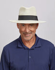 Middle-aged man smiling and looking straight, wearing a Cream Afternoon Fedora Hat and a dark blue polo shirt.