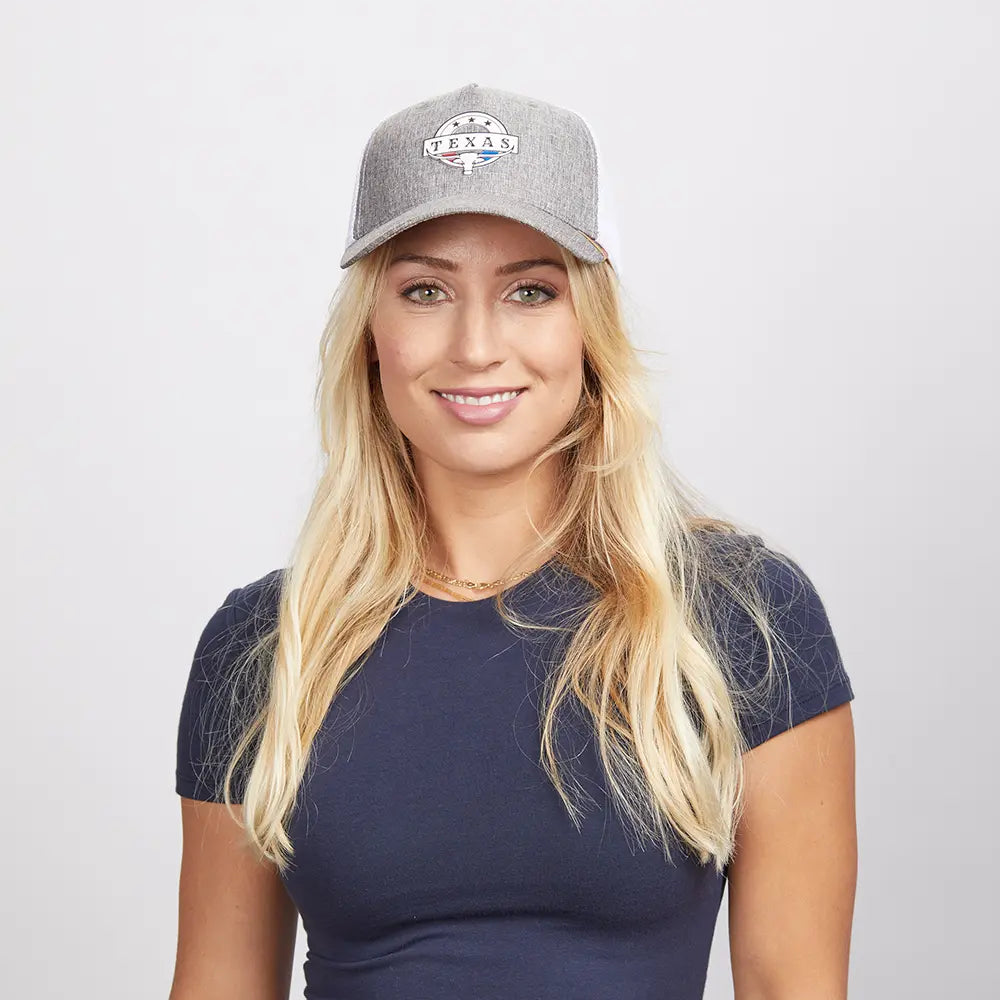 A blonde woman wearing a grey mesh poly cap and a blue shirt