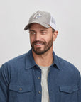 A man wearing a gray Texas cap and blue button-up shirt 