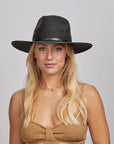 A blonde woman wearing a Titus Sun Hat and a brown top.