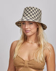 A blonde woman wearing a Tootie Bucket Hat and a brown knitted top, looking slightly to the side with a subtle smile.