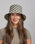 Woman wearing a Tootie Bucket Hat, smiling slightly, with long dark hair and wearing a gray top