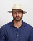 A man wearing a blue polo and the Tulum Straw Sun Hat